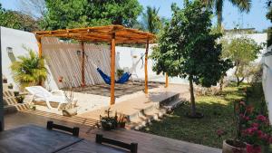 梅里达Hotel Monserrat的庭院中带凉棚的木甲板