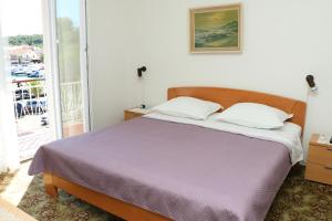une chambre avec un lit et un balcon dans l'établissement Apartments and rooms by the sea Kukljica, Ugljan - 24327, à Kukljica
