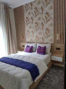 a bedroom with a large bed with purple pillows at Diar kamiliya in Meknès