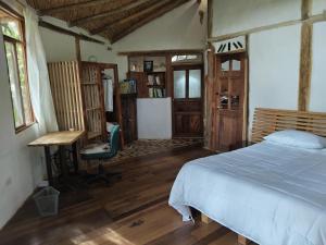 a bedroom with a bed and a desk and window at Zuna in Sutamarchán