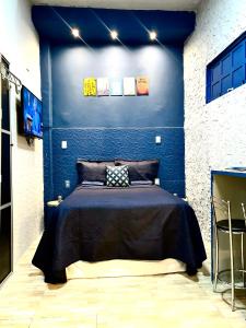 a bedroom with a bed in a blue wall at É de casa unidade 02 centro in Juazeiro do Norte