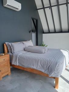 a bedroom with a bed with a fan on the wall at Villa cecile in Balian +23 photos
