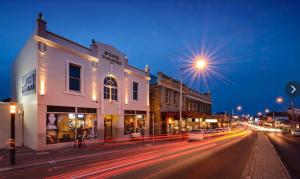 a city street at night with buildings and street lights at Lizzy's Hideaway, Close to City in West Hobart