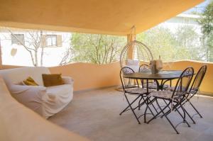 a table and chairs in a room with a table and a couch at Oasi di Pace con Terrazzo - 5min Spiaggia Budoni in Brunella