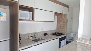 a kitchen with a sink and a microwave at Ilha Pura BARRA apart in Rio de Janeiro +16 photos