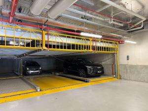 two cars in a parking garage with yellow shelves at Modern 1b Apt Near Swinburne University in Melbourne