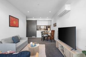 a living room with a large flat screen tv at Modern 1b Apt Near Swinburne University in Melbourne