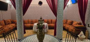 a room with couches and a table with a vase with flowers at Riad Raffaa in Marrakesh