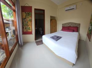 a bedroom with a large white bed with red pillows at Suci's Friendly Apartments in Mataram +79 photos
