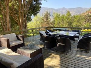 a deck with a table and chairs and a table and chairs at Bellísima casa en La Aurora in Curacaví