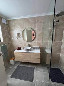 a bathroom with a sink and a mirror at Blackbird Cottage Tiny Home in Thirlmere +22 photos