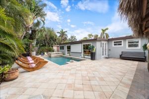 那不勒斯Chic Pool Naples Beach House的带游泳池和房子的后院