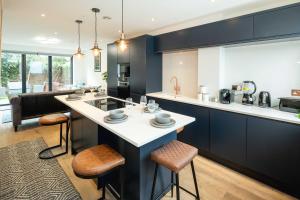 a kitchen with a large island with bar stools at Gorgeous 3BR 2bath house in O2 Greenwich with parking in London