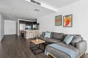 un soggiorno con un divano e un tavolo di Luxury Darling Harbour Views, Pool & Parking a Sydney