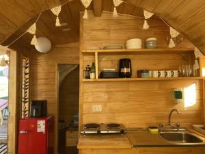 a kitchen with a sink and a red refrigerator at Cabañas Las Capuchinas in Tomé