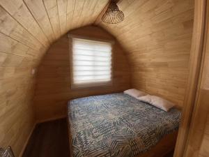 a small room with a bed and a window at Cabañas Las Capuchinas in Tomé