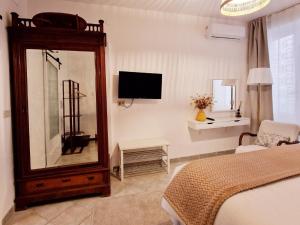 a bedroom with a mirror and a bed and a tv at Donna Rosa - Your Home in Taormina in Taormina