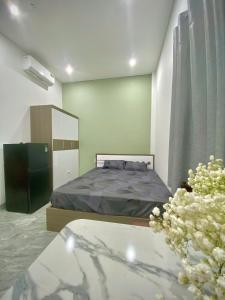 a bedroom with a bed and a table with flowers at HG House in Da Nang