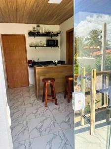 una cucina con un bancone e sgabelli in una stanza di Flats Rota dos Corais a São Miguel dos Milagres Altre 8 foto