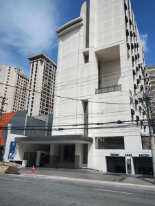 a white building on a street with tall buildings at Hotel Aeroporto Congonhas in São Paulo +10 photos