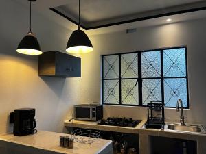 a kitchen with two lights and a stove and a window at Casa Don Beni in Xicotepec de Juárez +5 photos