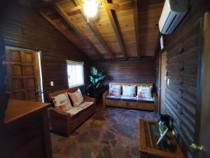 a living room with two couches and a window at Hotel La Leyenda Sonora in El Saucito