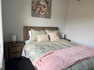 a bedroom with a bed with a pink blanket at Amaroo holiday home in Kingscote