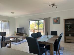 a living room with a wooden table and chairs at Amaroo holiday home in Kingscote