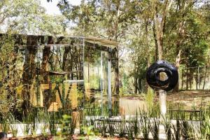 a glass building with a sculpture in a garden at Casa Darzana in Mazatla