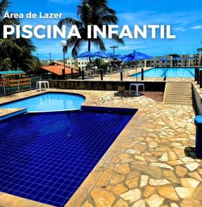 a swimming pool in a resort with blue tiles on the ground at Apartamento Térreo 2 Quartos Com Clube Privativo - Condomínio Marina Clube in Cabo Frio