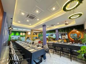 a dining room with tables and chairs in a restaurant at Cambana Poipet Hotel in Krong Poi Pet