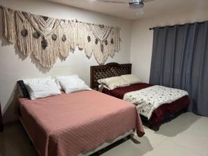 a bedroom with two beds and a window with curtains at Casa del artista in Mérida +28 photos