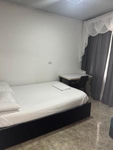 a bed in a room with a desk and a bed sidx sidx sidx at Habitación escala aeropuerto in Palmira