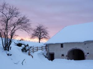 a barn covered in snow with a fence and trees at Gîte Vosges : nature, cheminée, animaux acceptés - FR-1-583-379 in Corravillers