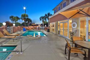 a swimming pool with tables and chairs next to a building at SummerPlace Inn in Destin