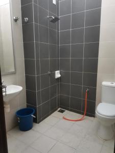 a bathroom with a shower with an orange hose at FA homestay in Kuantan +4 photos