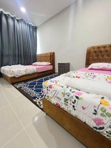 two beds sitting in a room withskirts at TAMU HOMESTAY Alam Mutiara in Kuala Terengganu