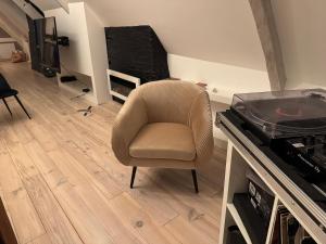 einen Stuhl in einem Wohnzimmer neben einem TV in der Unterkunft Les remparts de Guerande in La Celle-sous-Gouzon