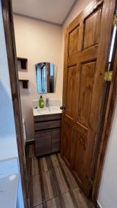 a bathroom with a sink and a wooden door at Zaza Flats Jaco #5 New basic STUDIO APARTMENT - no extras, simple in Jacó +22 photos