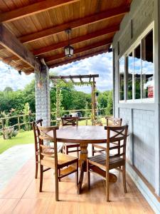 a wooden table and chairs on a patio at Chácara Passaúna in Curitiba