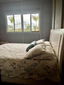a bed in a bedroom with two windows at Chácara Passaúna in Curitiba +96 photos