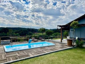 a backyard with a swimming pool and a deck at Chácara Passaúna in Curitiba