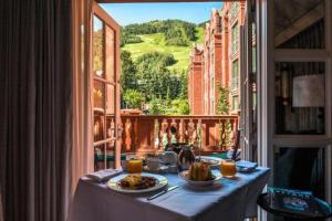 a table with two plates of food on a balcony at Luxury 2 Bedroom Residence At The St Regis Residence Club In Downtown Aspen in Aspen