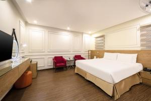 a bedroom with a bed and two red chairs at A25 Hotel - 21 Le Duc Tho in Hanoi