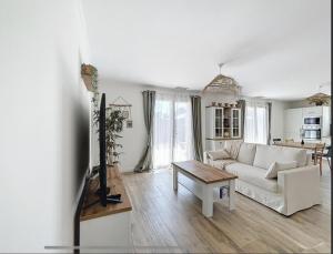 a living room with a white couch and a table at Villa on Arcachon Bay in Audenge
