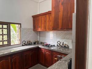 a kitchen with wooden cabinets and a stove top oven at Selvarani mansion in Jaffna