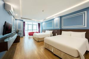a hotel room with two beds and a flat screen tv at A25 Hotel - 21 Le Duc Tho in Hanoi +17 photos