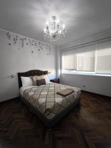 a bedroom with a bed and a chandelier at Lindo apartmento en PLAZA PRINCIPAL in Lima +77 photos