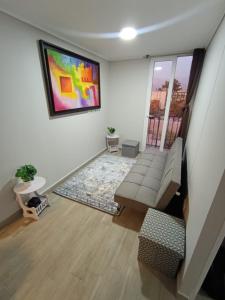 a living room with a couch and a painting on the wall at Movistar Arena - Fantasilandia - Apartment Parking in Santiago