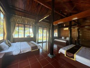 a bedroom with two beds in a room with windows at River Homestay in Hàm Tân